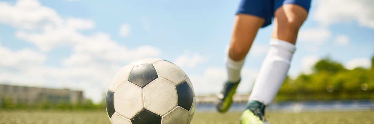 Boy Kicking Ball in Football